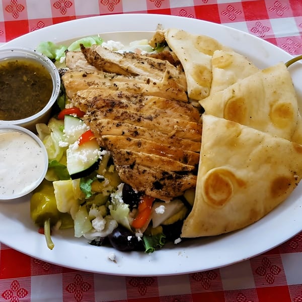 Bada Bing Grill's Greek chicken salad with pita bread, two dressings, and a pepperoncini.